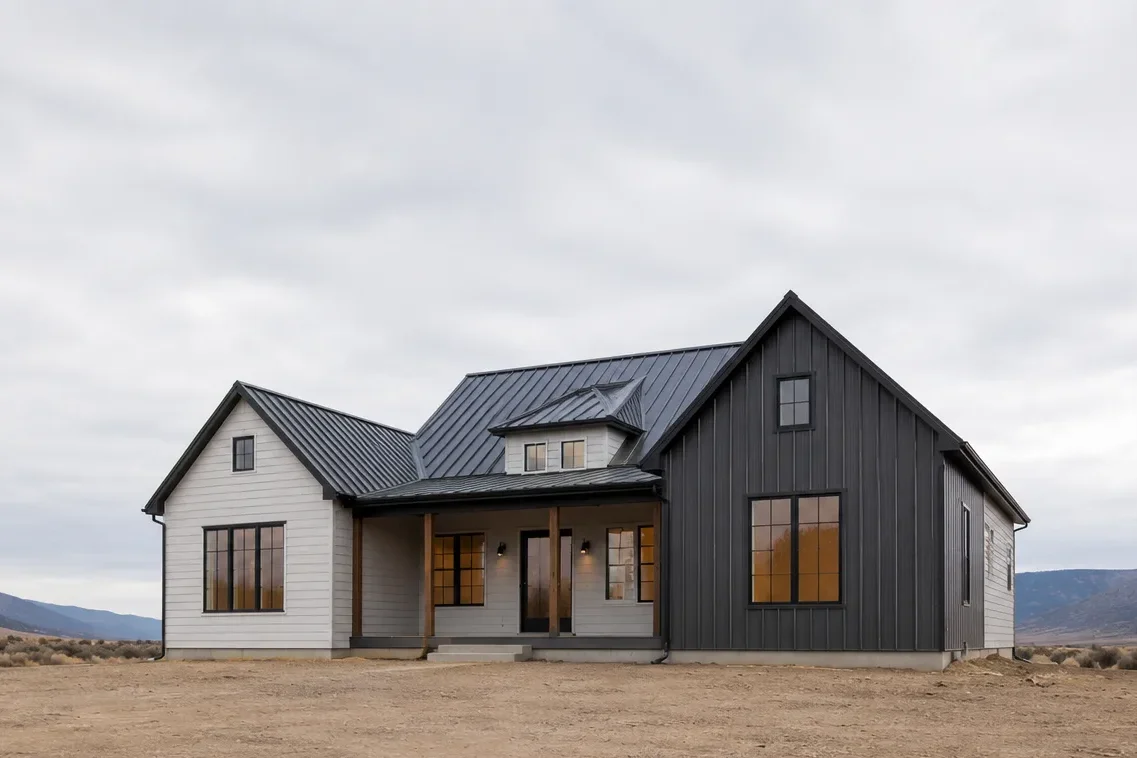 White farmhouse with a dark metal roof and covered front porch