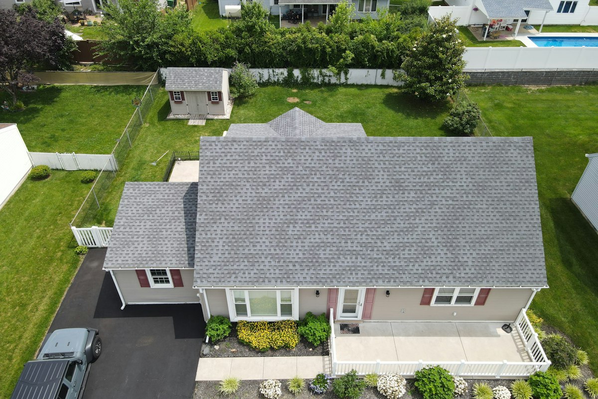 Aerial view of a suburban home with a new gray shingle roof
