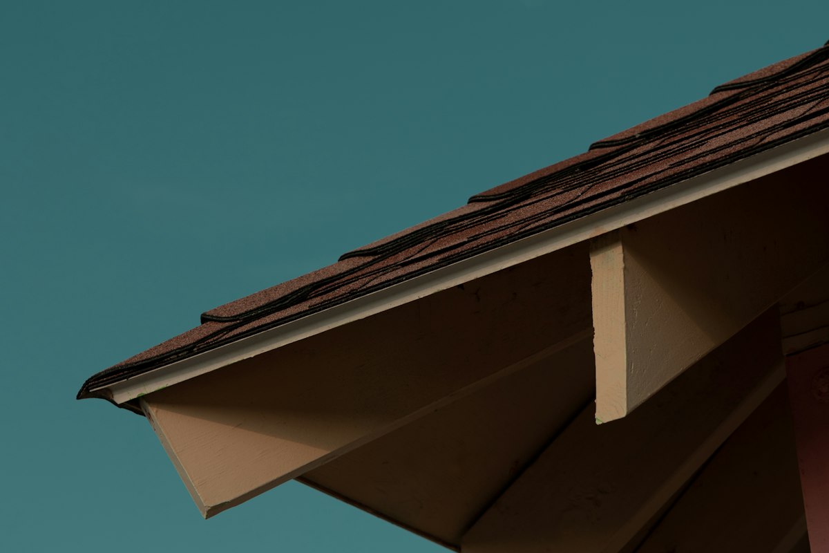 Roof eave showing finished soffit and fascia against a blue sky